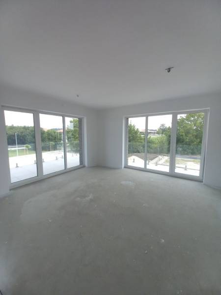 Große Fenster und natürliches Licht in einer 2-Zimmer-Wohnung, die einen Blick ins Grüne bieten.