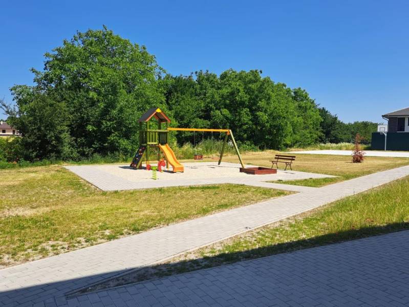 Ein Kinderspielplatz mit Klettergerüsten und Schaukeln in Galanta, umgeben von Grünflächen und Gehwegen.