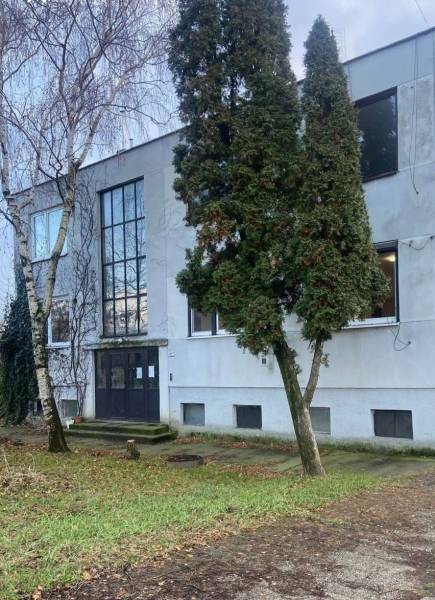 Das Äußere des Gebäudes in Selice, umgeben von Bäumen und einer grasbewachsenen Umgebung.