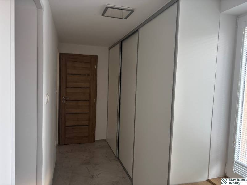 Der Flur in einem Einfamilienhaus mit einem Schiebetürenschrank und Holztüren.