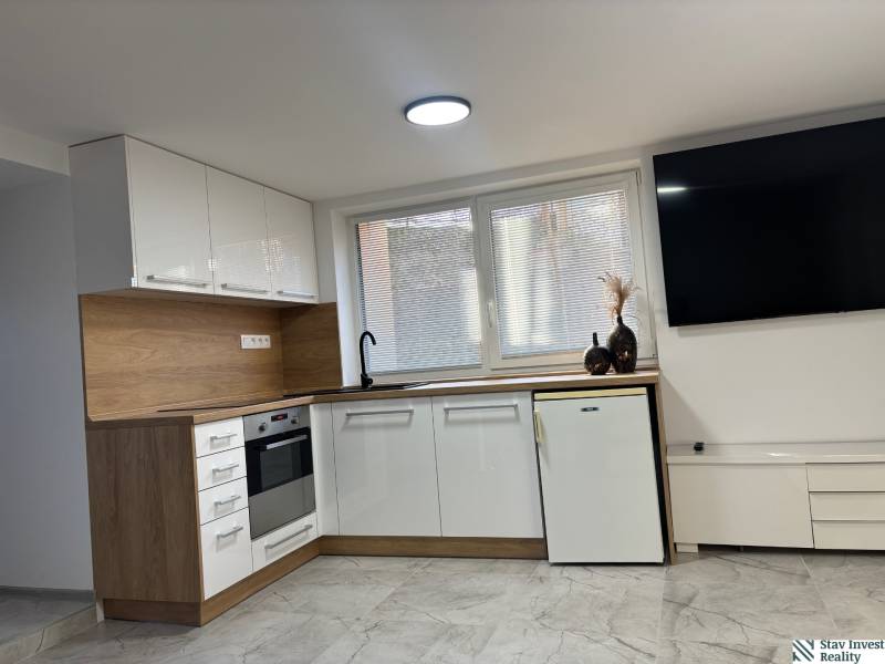 Küche in einem Einfamilienhaus mit weißen Schränken und Holzelementen.