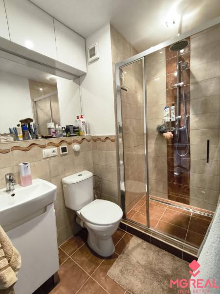 Badezimmer einer Einzimmerwohnung, Duschkabine, Waschbecken, WC und Schränke.