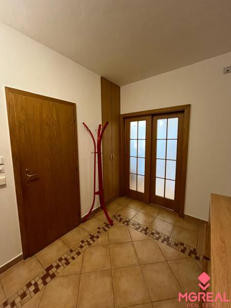 Flur einer 3-Zimmer-Wohnung mit Fliesenboden und Holztüren.