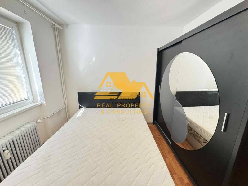 Schlafzimmer in einer 3-Zimmer-Wohnung mit Bett, Schrank und Holzboden.