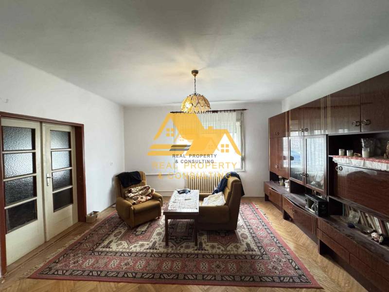 Wohnzimmer in einem Einfamilienhaus mit Holzboden und reichhaltiger Möblierung.