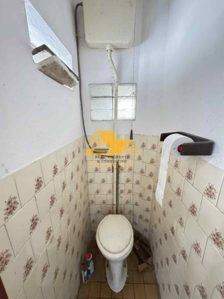 Ein Badezimmer mit älteren Fliesen in einem Einfamilienhaus.