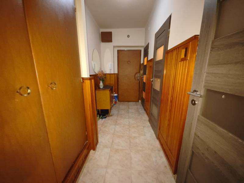 Ein Flur mit Holzvertäfelung und Einbauschränken in einer 3-Zimmer-Wohnung.