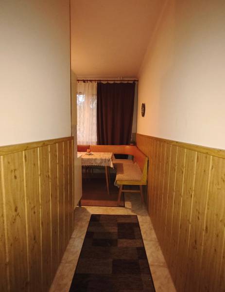 Ein schmaler Flur, der zum Esszimmer mit einer Bank in einer 3-Zimmer-Wohnung führt.