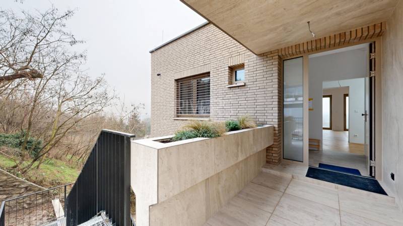 Eingang zum Einfamilienhaus in der Révová in Bratislava - Altstadt, Ziegelfassade, Gartenbepflanzung.