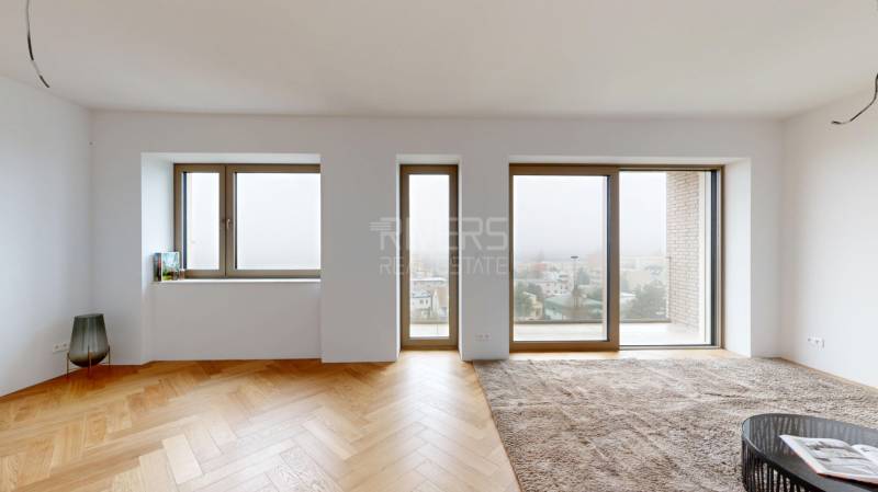 Innenraum eines Einfamilienhauses mit großen Fenstern und einem Boden in Holzoptik.