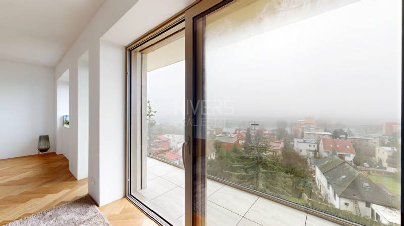 Blick aus einem hellen Zimmer mit Holzboden in einem Einfamilienhaus.