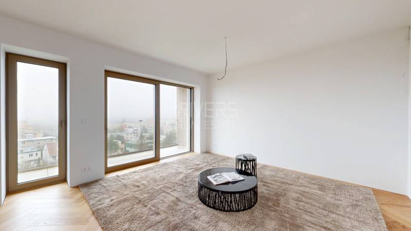 Wohnzimmer in einem Einfamilienhaus mit großen Fenstern, Teppichboden und Holzbodenoptik.