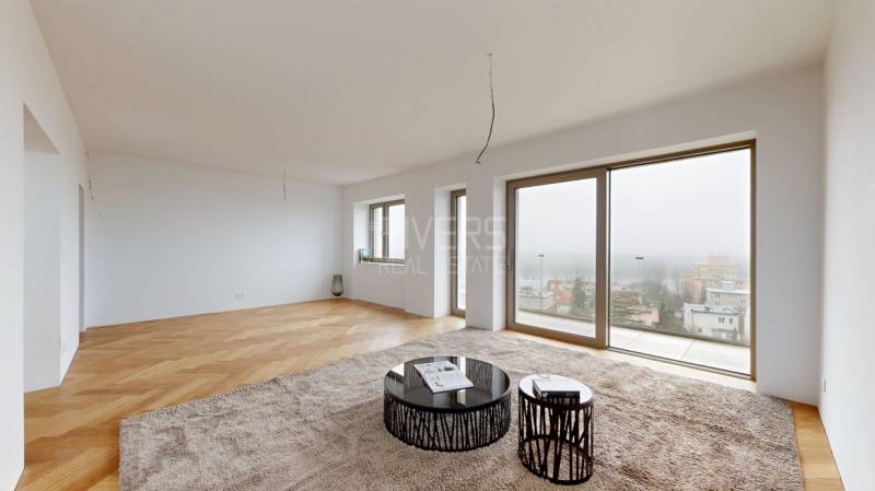 Wohnzimmer in einem Einfamilienhaus mit Holzboden und großen Fenstern.