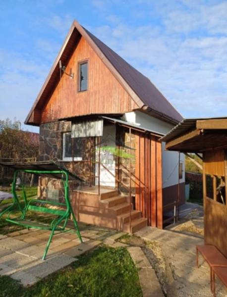 Eine Hütte in Pozdišovce mit Holzverkleidung und einer Schaukel im Garten.