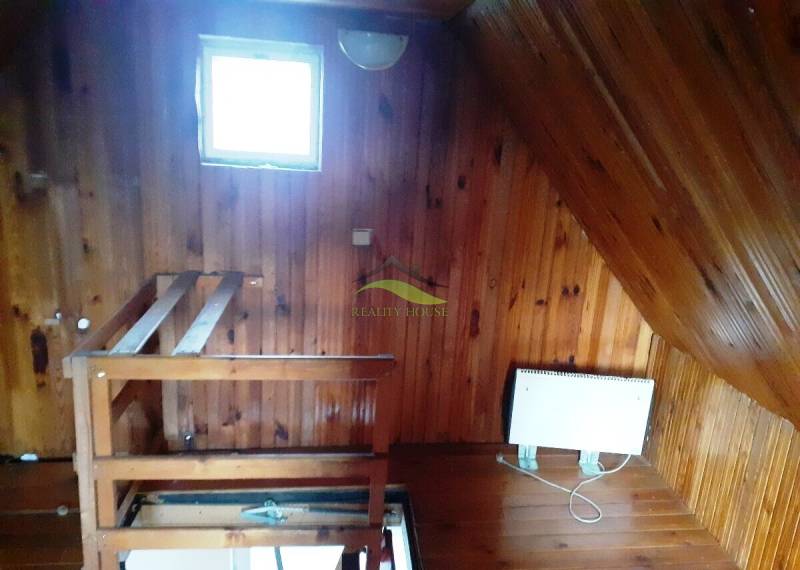 Innenraum der Hütte mit Holzboden und Treppe.