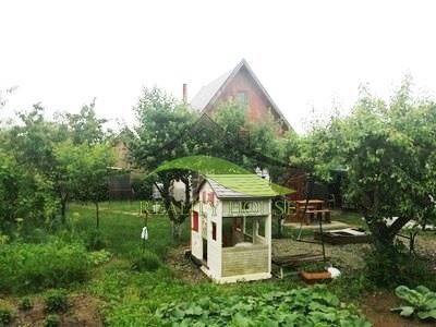 Garten in Pozdišovce mit einem Kinderspielhaus und Obstbäumen bei der Hütte.