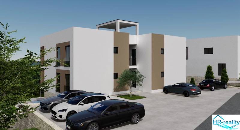 Ferienwohnung in Ciovo mit geparkten Autos und umliegendem Grün.