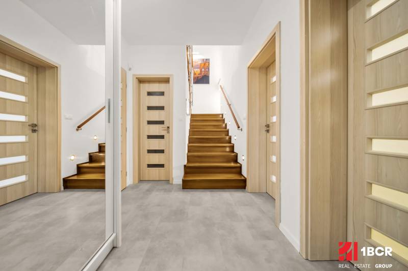 Eingangshalle in einem Einfamilienhaus mit Holzboden und Treppe.