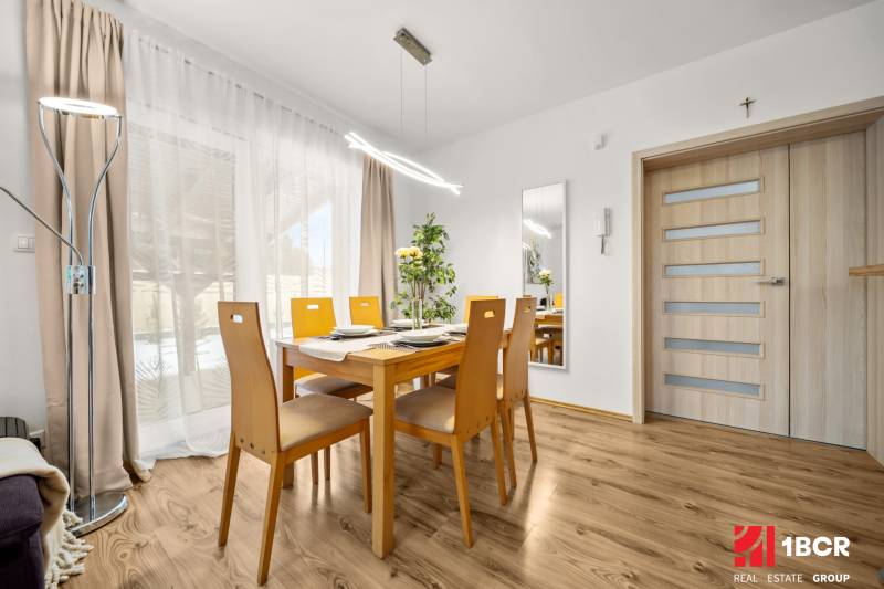 Esszimmer mit Holztisch und Boden in Holzoptik in einem Einfamilienhaus.