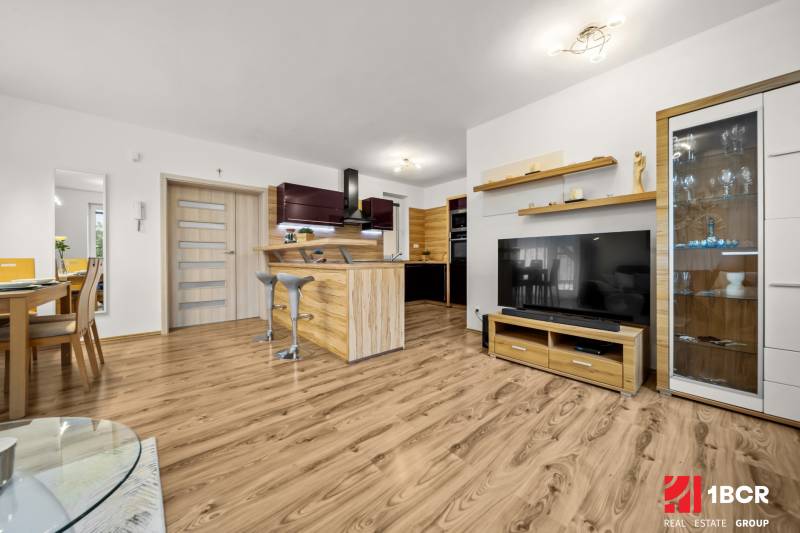 Wohnzimmer im Einfamilienhaus mit Küche und Holzboden.