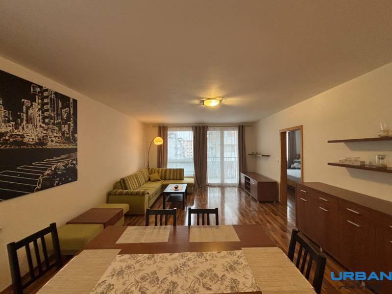 Wohnzimmer mit Holzboden, Sofa und Esstisch in einer Zweizimmerwohnung.