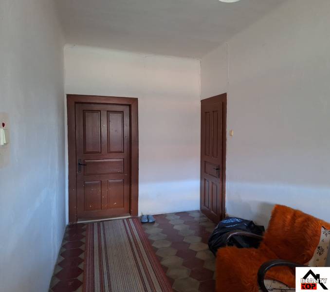 Interieur eines Einfamilienhauses mit Türen, einem Sessel und einem Teppichläufer.