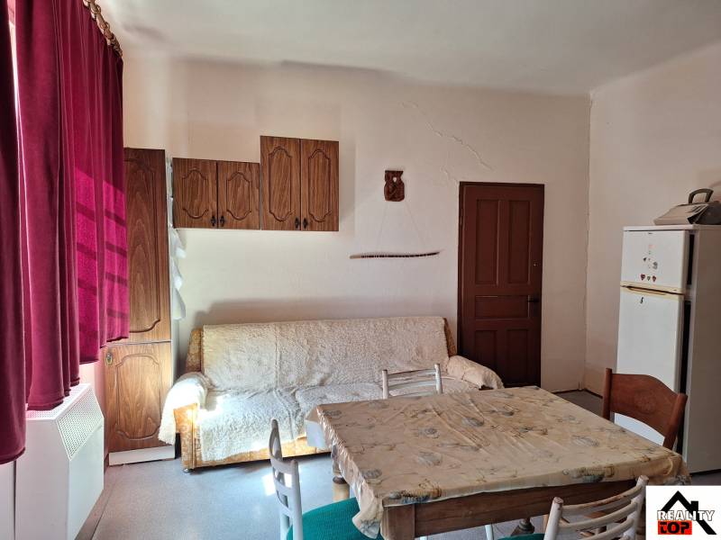 Innenraum eines Einfamilienhauses mit Sofa, Esstisch und Holzschränken.