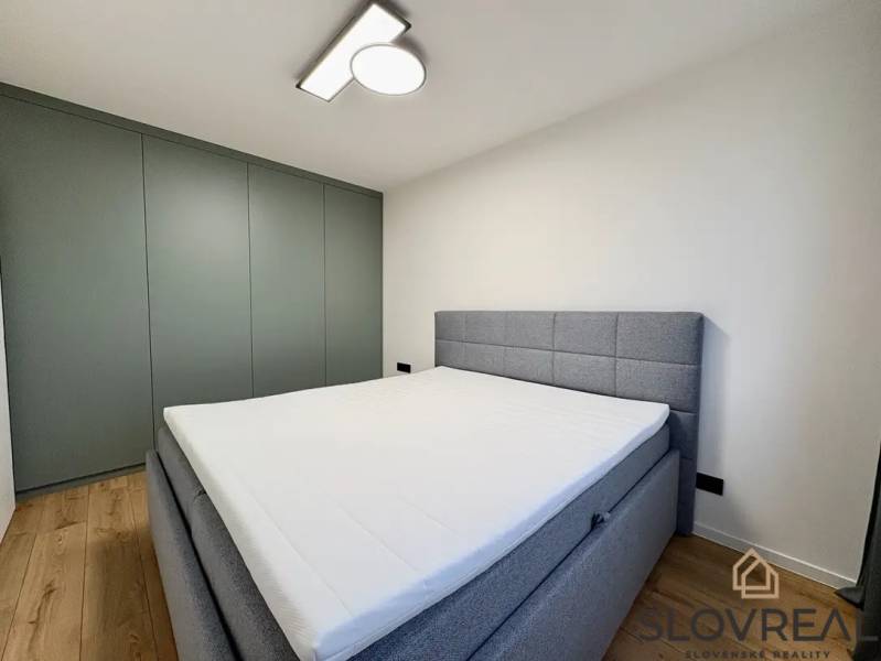 Ein stilvolles Schlafzimmer in einer 3-Zimmer-Wohnung mit Holzboden und moderner Beleuchtung.