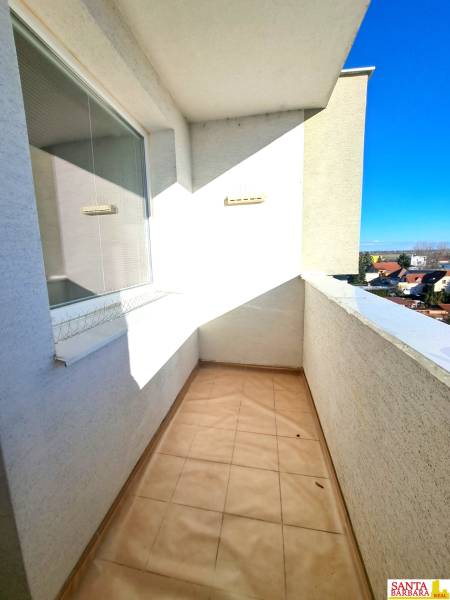 Der Balkon einer 4-Zimmer-Wohnung mit Blick auf die Dächer der Häuser und einen klaren Himmel.