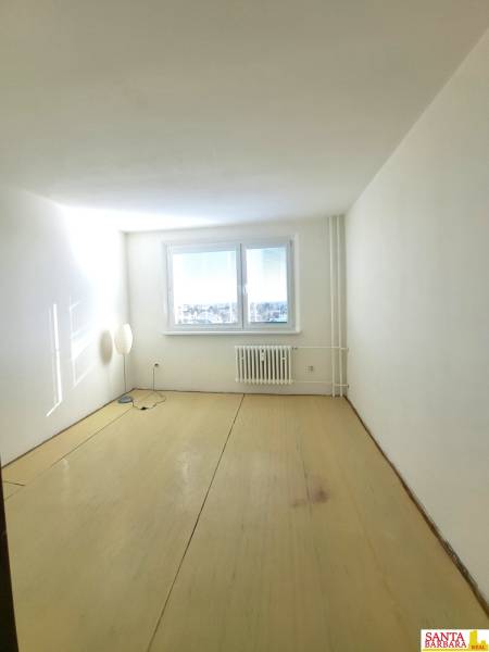 Ein Zimmer in einer 4-Zimmer-Wohnung mit Fenster und Lampe, Boden mit Holzdekor.