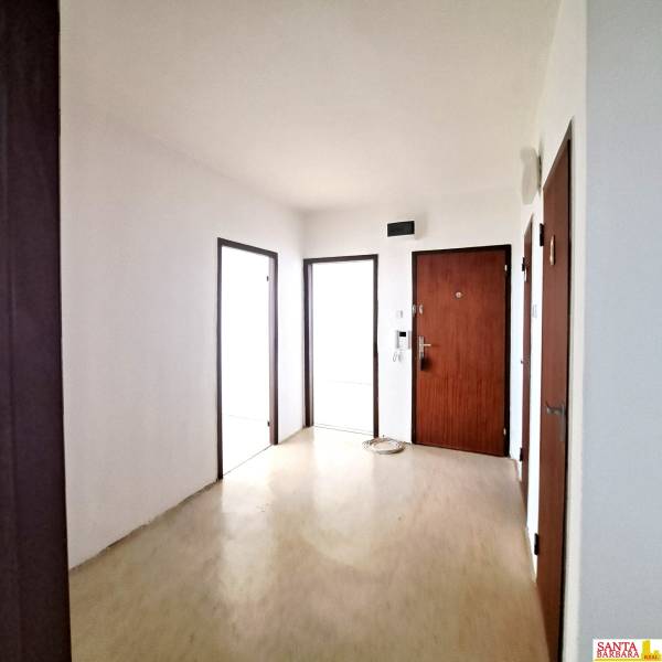 Eingangsbereich einer Vierzimmerwohnung mit Holzboden und Holztüren.