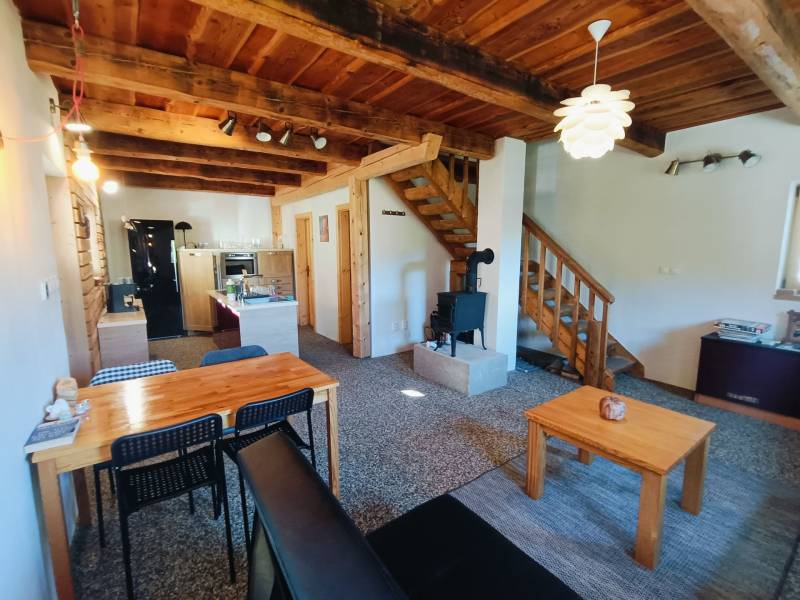 Das Innere der Hütte mit einem Boden in Holzoptik, einer Holzdecke und einem Kachelofen.