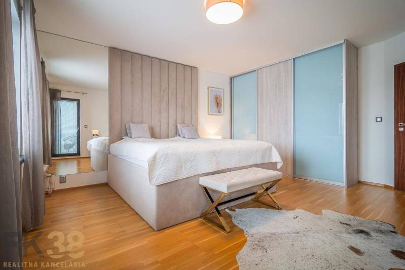 Schlafzimmer im Einfamilienhaus mit Bett, Holzboden und Fellteppich.