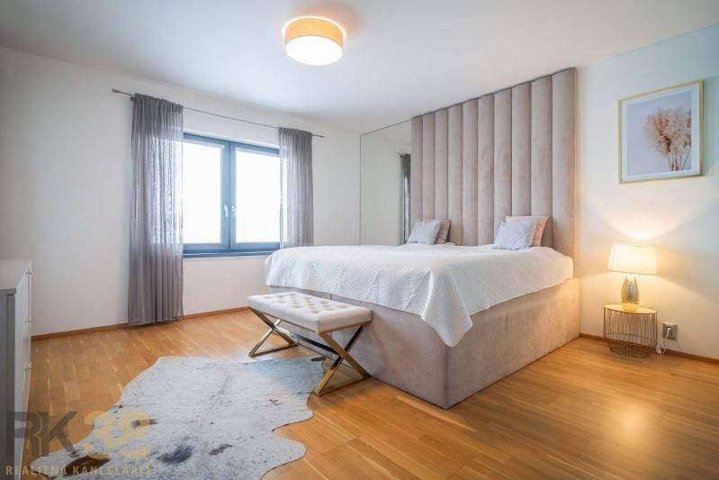 Schlafzimmer im Einfamilienhaus mit Bett, Holzboden und Fellteppich.