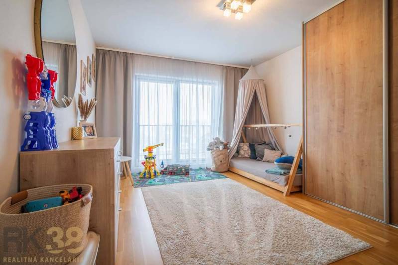 Kinderzimmer mit Spielzeug, Bett und Schrank, Boden mit Holzdekor in einem Einfamilienhaus.