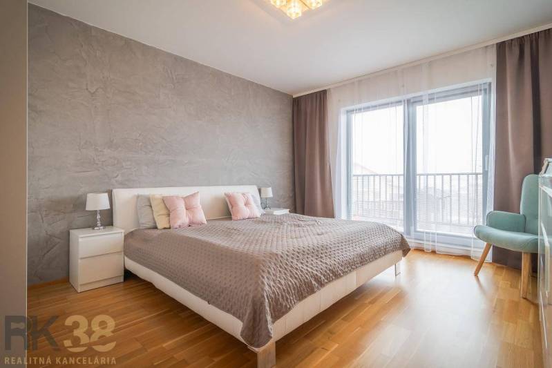 Schlafzimmer in einem Einfamilienhaus mit Bett, Nachttischen und Boden mit Holzdekor.