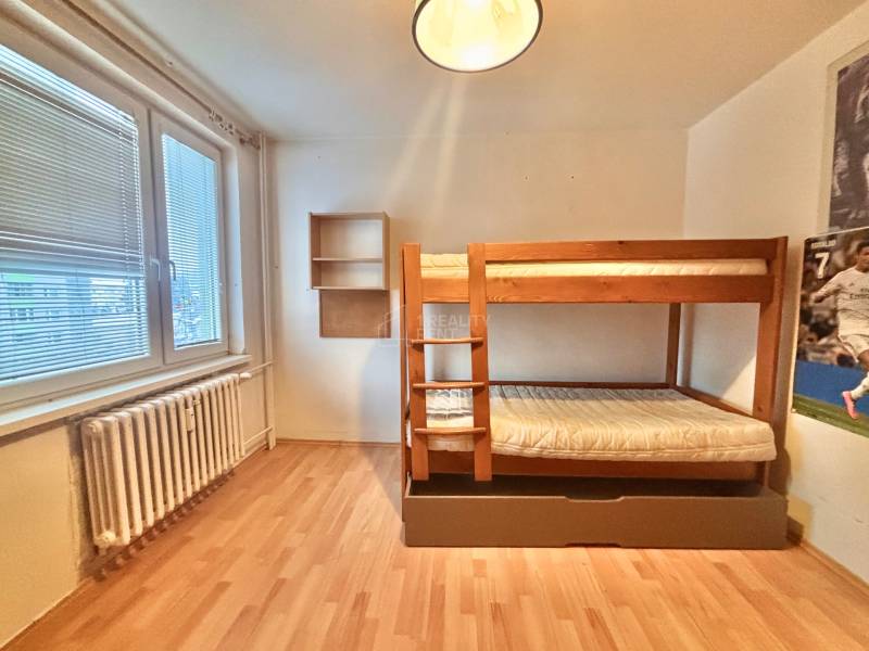Kinderzimmer in einer 3-Zimmer-Wohnung mit einem Etagenbett und einem Boden in Holzoptik.