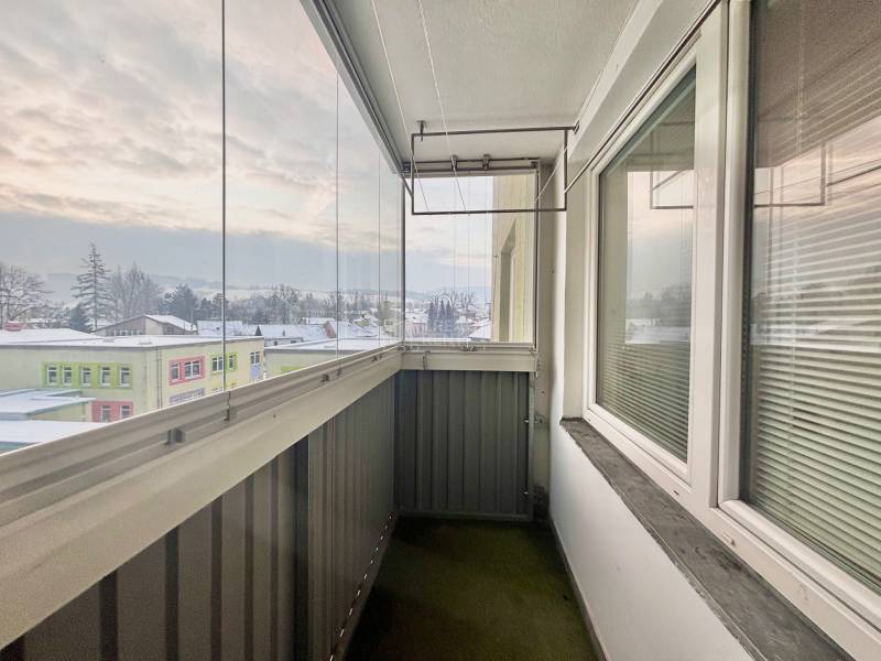 Ein verglaster Balkon mit Blick auf das verschneite Panorama der Stadt Turzovka in der Straße Centrum.