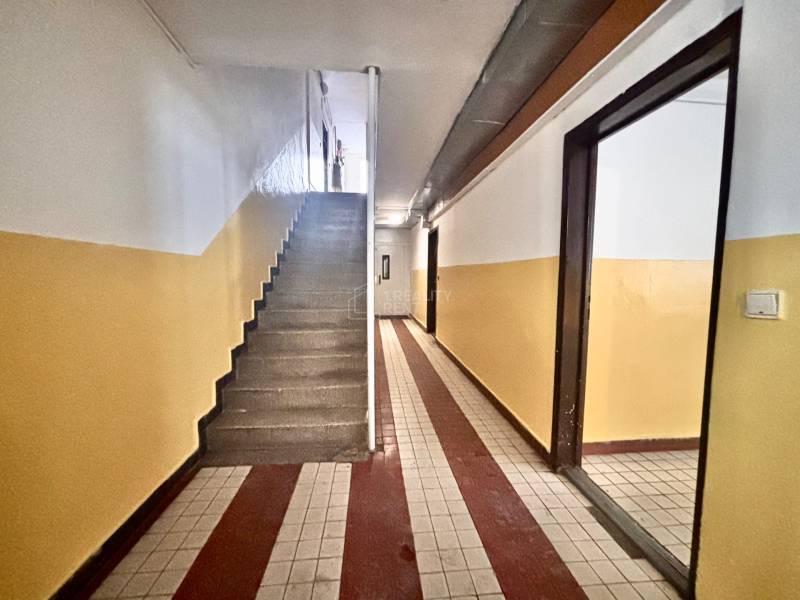 Eingangsflur mit Fliesen in einer 3-Zimmer-Wohnung, Treppenhaus und bunte Wände.