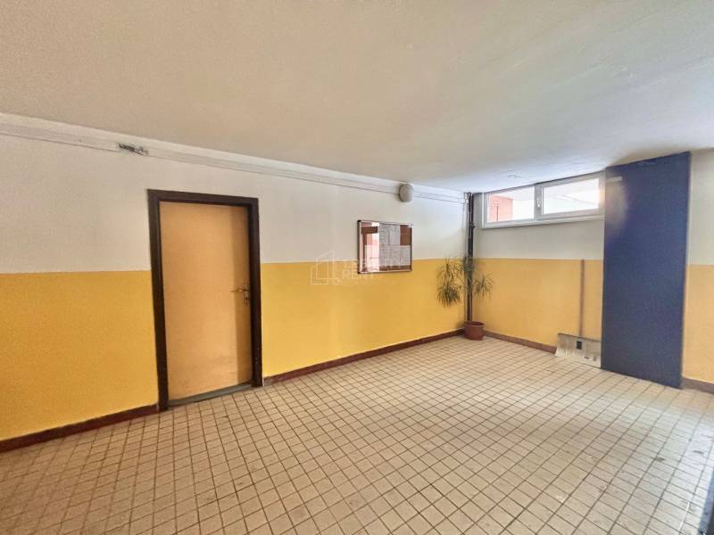 Der Flur in einem 3-Zimmer-Wohnhaus mit Fliesen, Türen und einer Pflanze in der Ecke.