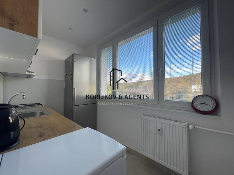 Küche in einer 3-Zimmer-Wohnung mit Blick durch Jalousien, einfache Einrichtung und Geräte.