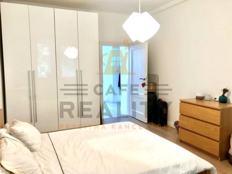 Schlafzimmer in einer 2-Zimmer-Wohnung mit weißem Schrank, Bett und Kommode.