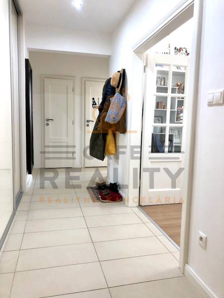 Flur in einer 2-Zimmer-Wohnung mit Einbauschrank und Fliesen.