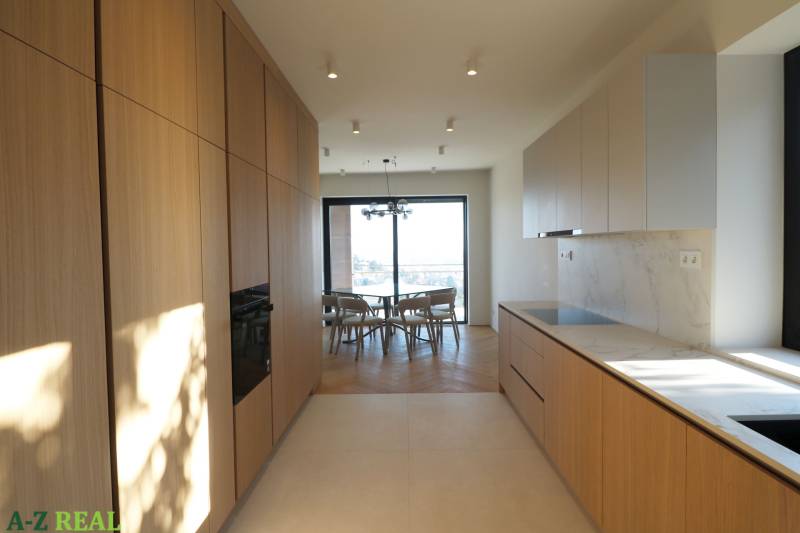 Küche in einer 4-Zimmer-Wohnung mit Holzboden und heller Küchenzeile.