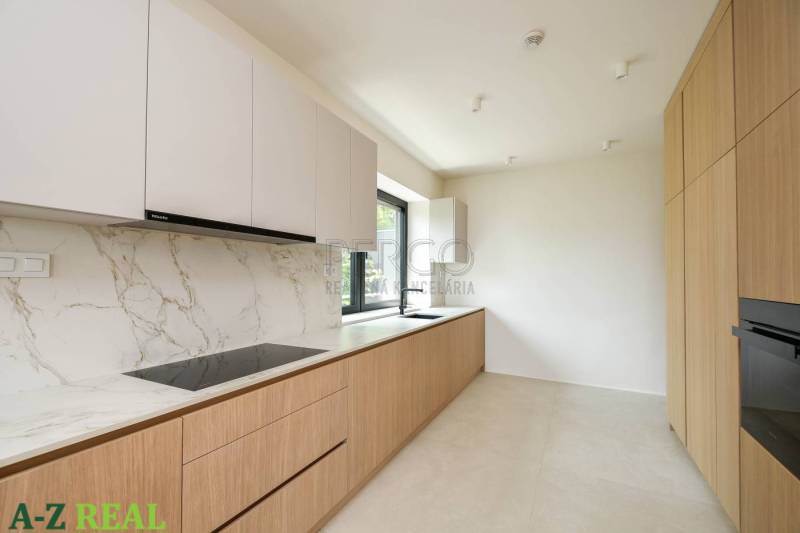 Küche in einer 4-Zimmer-Wohnung mit weißen Schränken, Marmoroberfläche und Holzelementen.