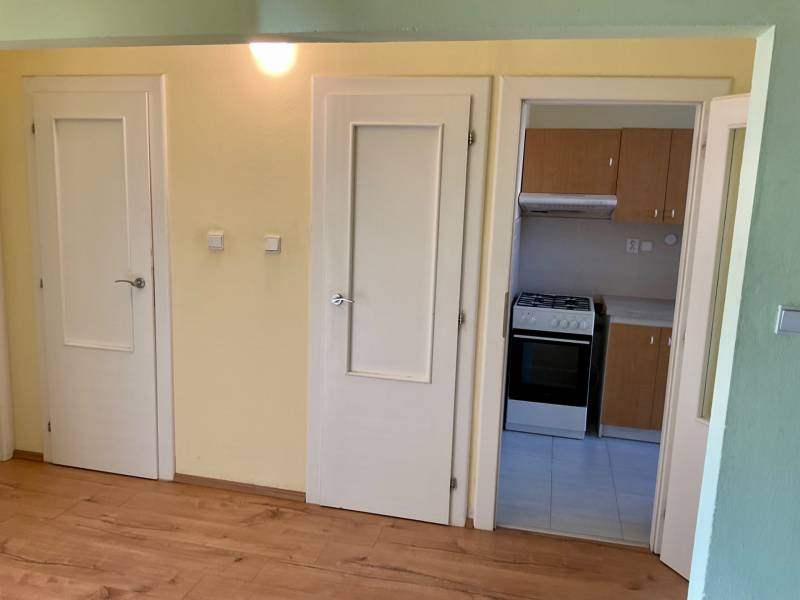 Innenraum einer 3-Zimmer-Wohnung mit Holzboden und Küchenzeile.