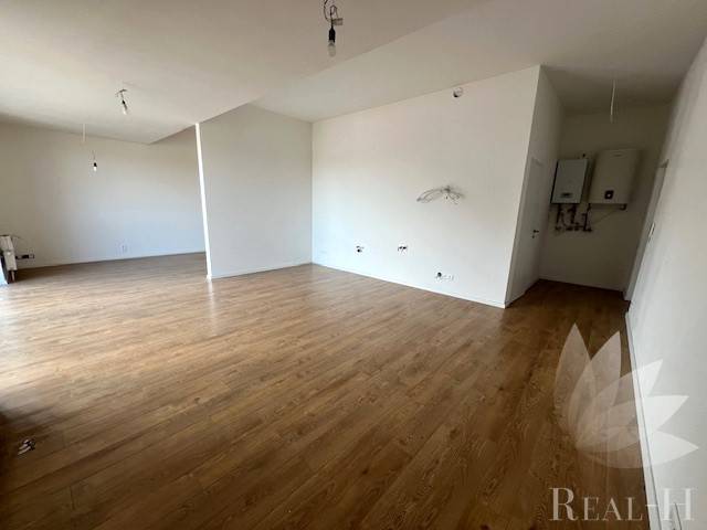 Innenraum einer 2-Zimmer-Wohnung mit Holzboden, weißen Wänden, offenem Raum.