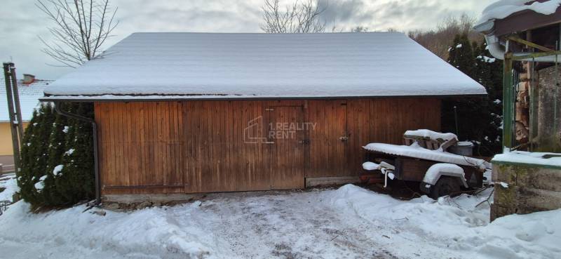 Auf dem Foto aus Ochodnica ist ein hölzerner, zusammenklappbarer Unterstand neben einem Einfamilienhaus mit einer Schneedecke.