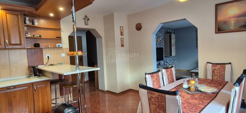 Esszimmer in einem Einfamilienhaus mit Holzelementen, Tisch und Stühlen, heller Innenraum.