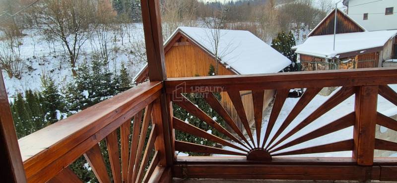 Verschneite Aussicht von einem Holzbalkon eines Einfamilienhauses in Ochodnica in der Straße Ochodnica.